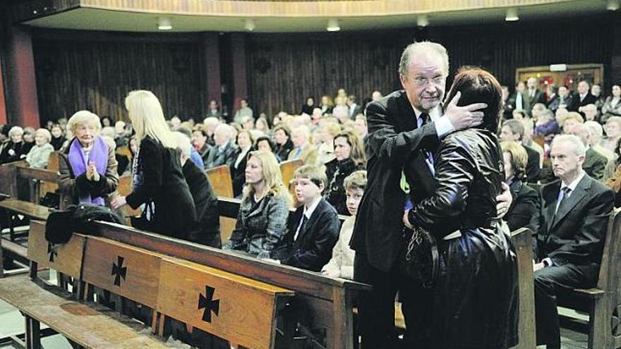 Ana Cristina, a la izquierda, y Leopoldo Tolivar, hijos de Cristina Alas, reciben condolencias momentos antes de iniciarse el funeral por su madre.