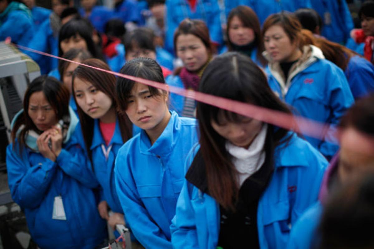 Empleats en vaga bloquegen l’entrada de la fàbrica on treballen a Xangai (Xina).