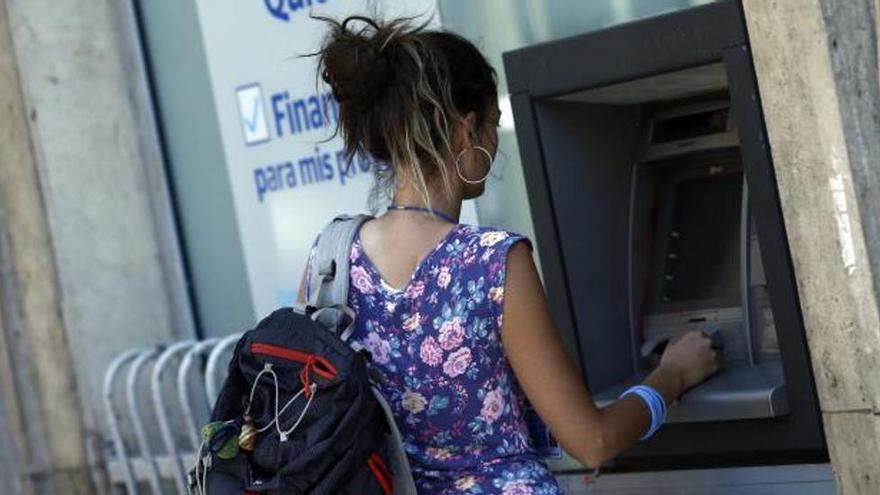 Una mujer operando en un cajero automático.