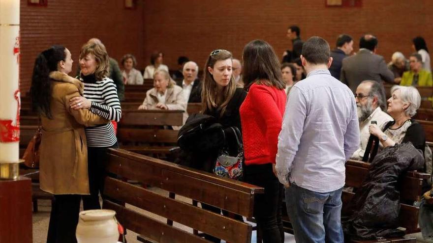 A la izquierda, Mari Carmen Fernández recibe el pésame de una amiga en el funeral. A la derecha, los dos hijos de Arturo Larroza, con una de las hijas de su pareja entre ambos. En primer término, la urna funeraria.