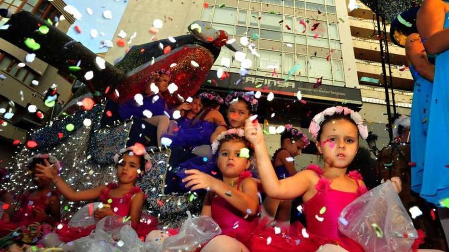 Un grupo de niñas lanzan pétalos de flores durante el desfile de las carrozas. // Iñaki Abella