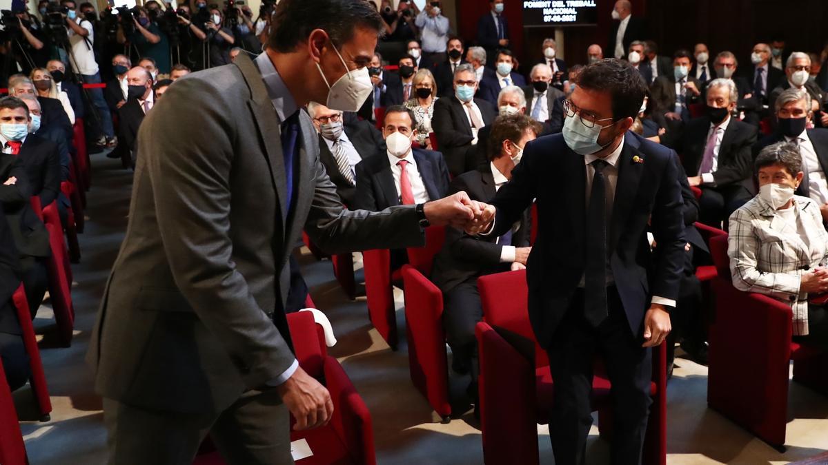 El presidente del Gobierno, Pedro Sánchez, y el 'president' de la Generalitat, Pere Aragonès, se saludan en el acto de entrega de la medalla conmemorativa de Foment del Treball, el pasado 7 de junio de 2021 en Barcelona.
