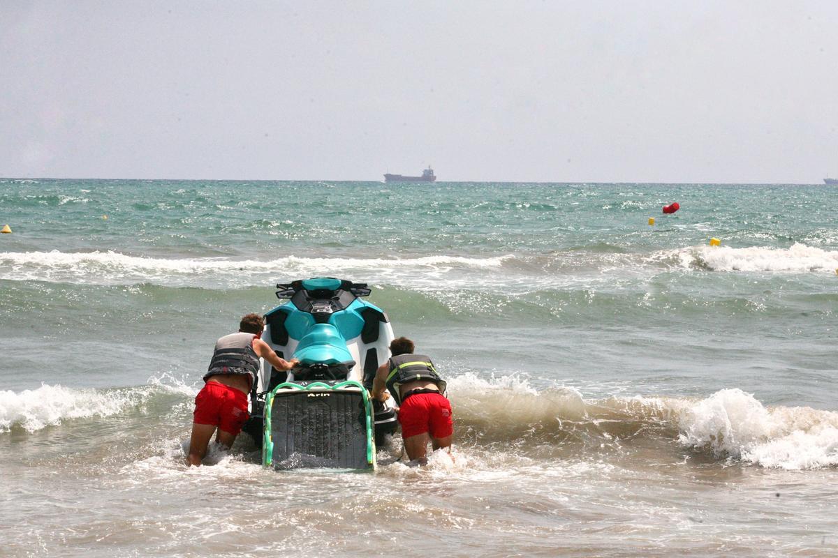Un socorrista y el patrón se adentran con la moto de agua en la playa del Pinar.