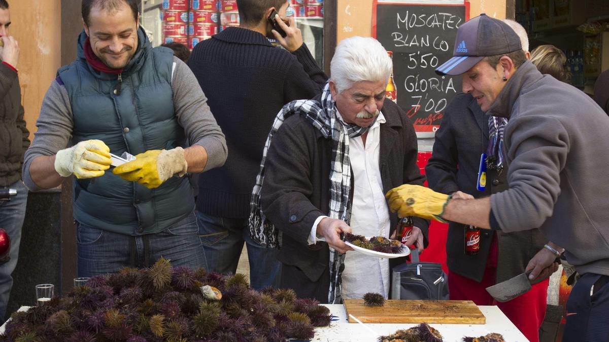 Varias personas comen erizo con motivo de una de las erizás de Cádiz para dar la bienvenida al carnaval.