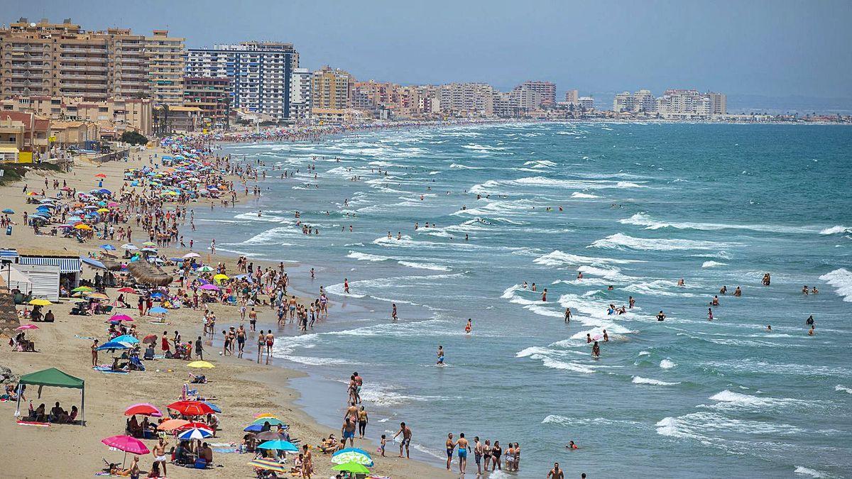 Turistas disfrutan de una jornada de playa en La Manga.