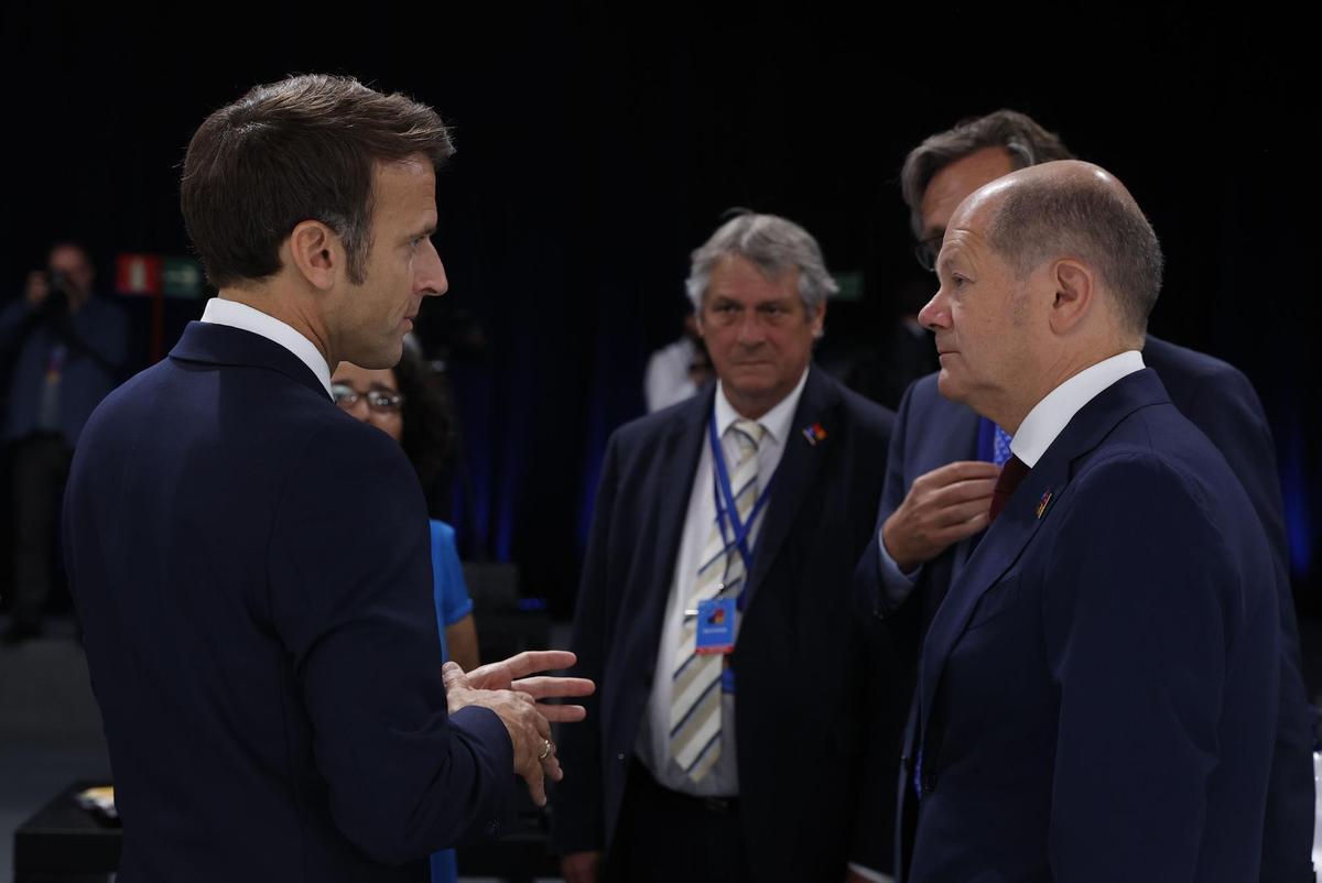 MADRID, 30/06/2022.- El presidente de Francia Emmanuel Macron (i) conversa con el canciller alemán Olaf Scholz durante la segunda jornada de la cumbre de la OTAN que se celebra este jueves en el recinto de Ifema, en Madrid. EFE/J.J. Guillén