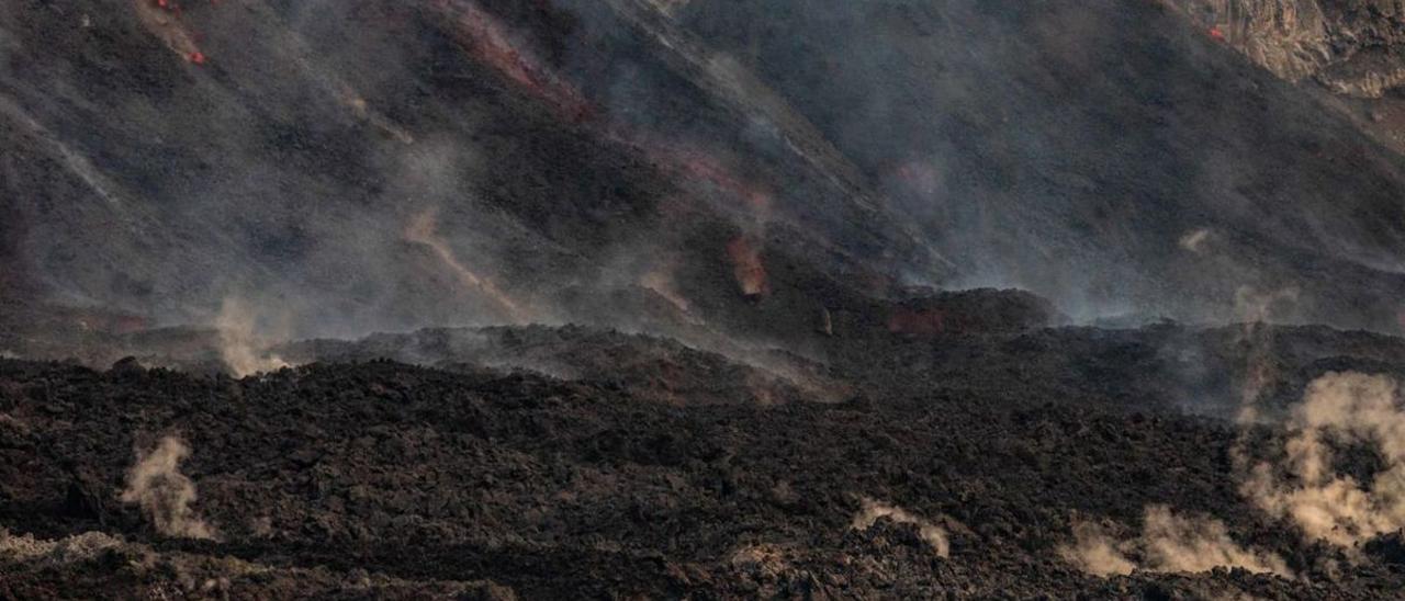 La lava fluye en forma de cascada hasta la fajana de la playa de Los Guirres. | |