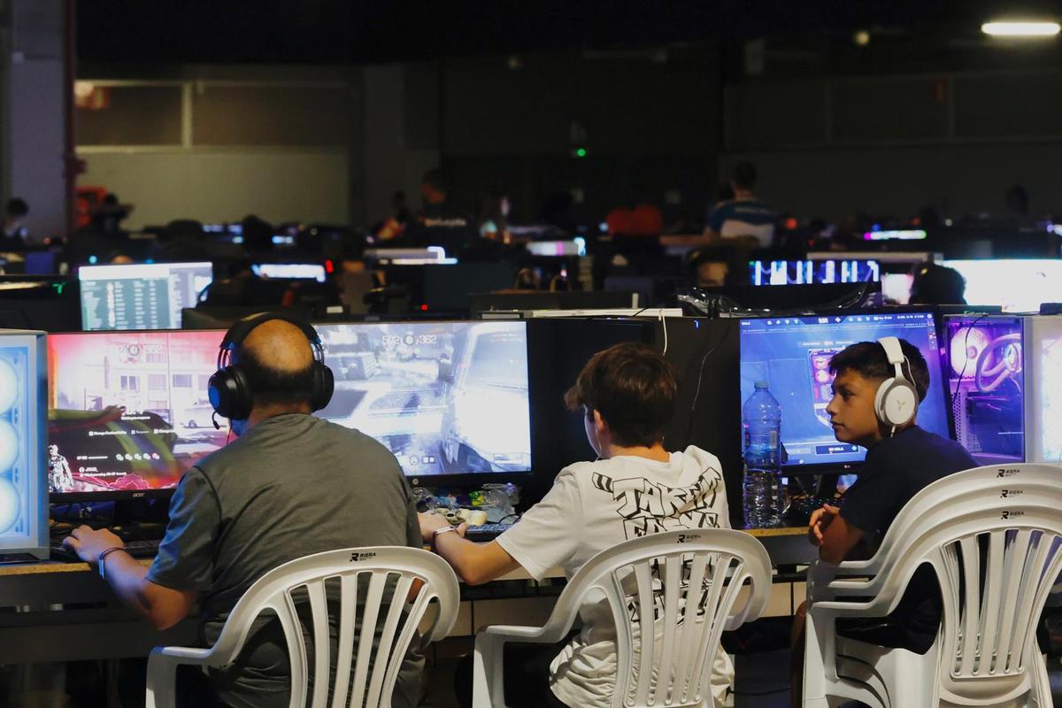 Un padre y un hijo juegan a videojuegos en Feria Valencia.