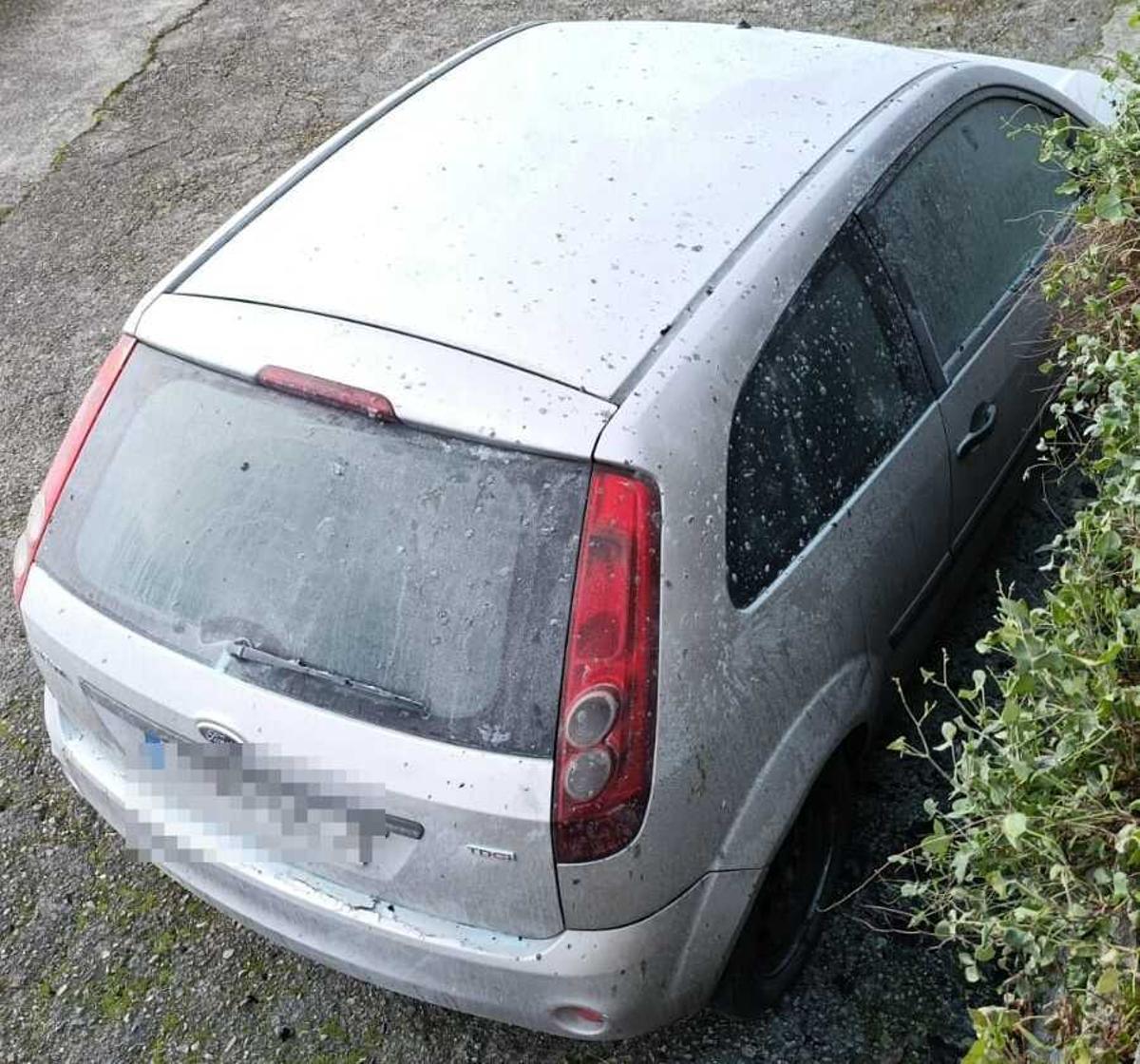 Daños en un vehículo aparcado al lado de un cubo de basura.