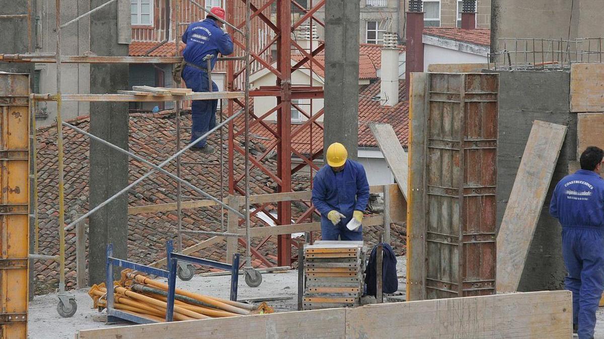 Varios obreros de la construcción levantan un edificio