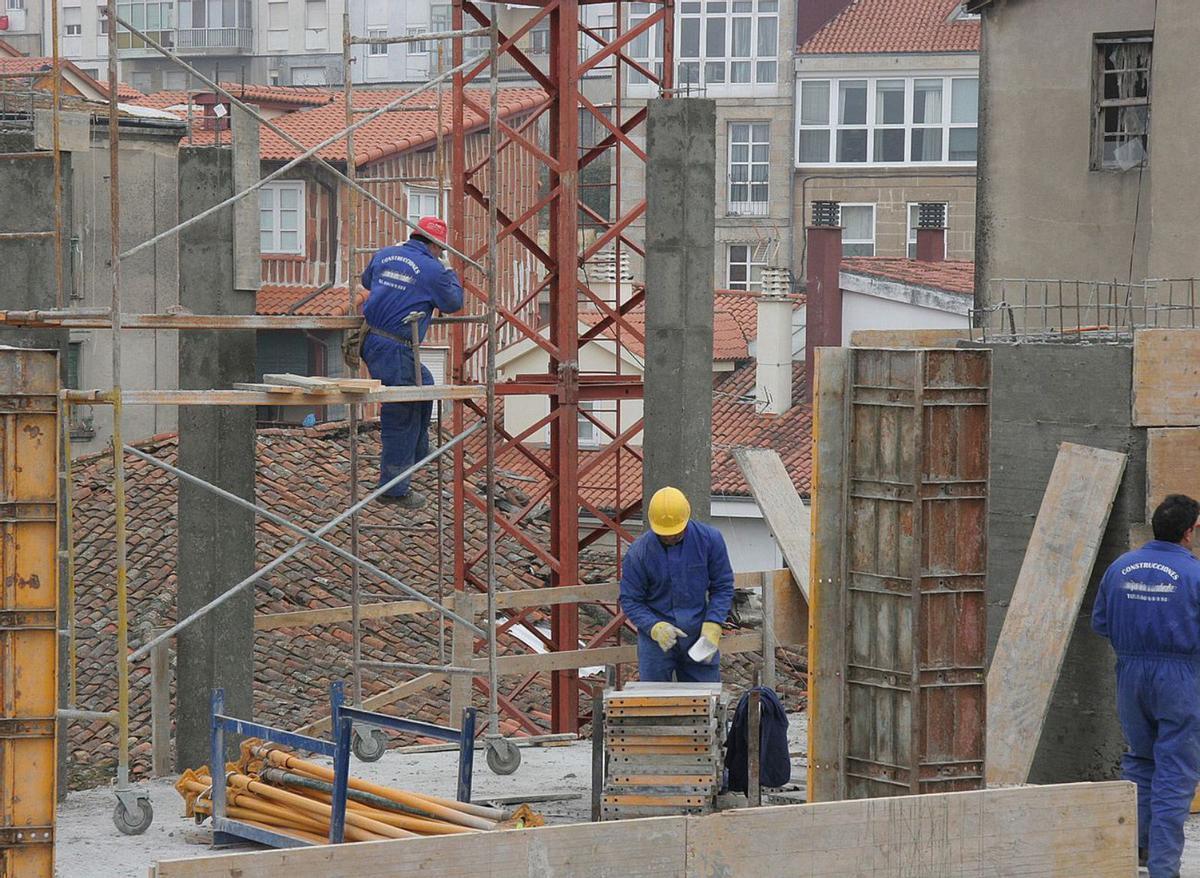 Varios obreros de la construcción levantan un edificio