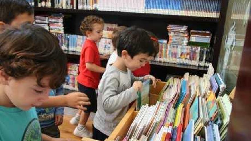 Un grupo de niños elige libros en una imagen de archivo.