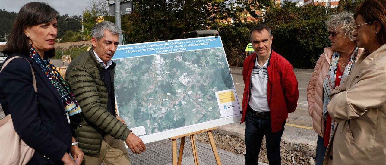 Por la izquierda, Nieves Roqueñí, Miguel Ángel Ruiz, Iván Fernández y vecinas de Cancienes, ayer, ante una imagen de la actuación llevada a cabo en la calle Puerto de Tarna, en Cancienes. | Mara Villamuza