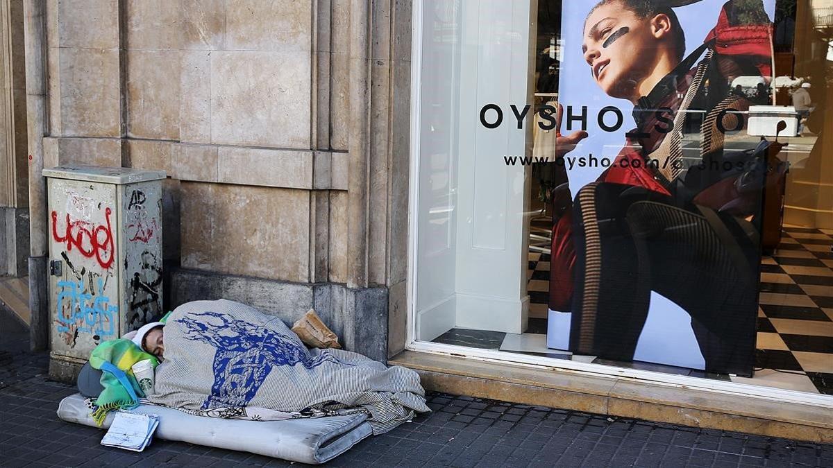 Archivo. Una persona sin hogar, durmiendo en una calle del centro de Barcelona. 