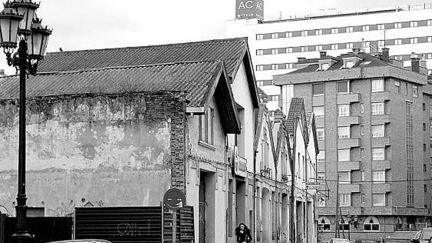 Las viejas naves de Ciudad Naranco. Al fondo, el hotel AC.