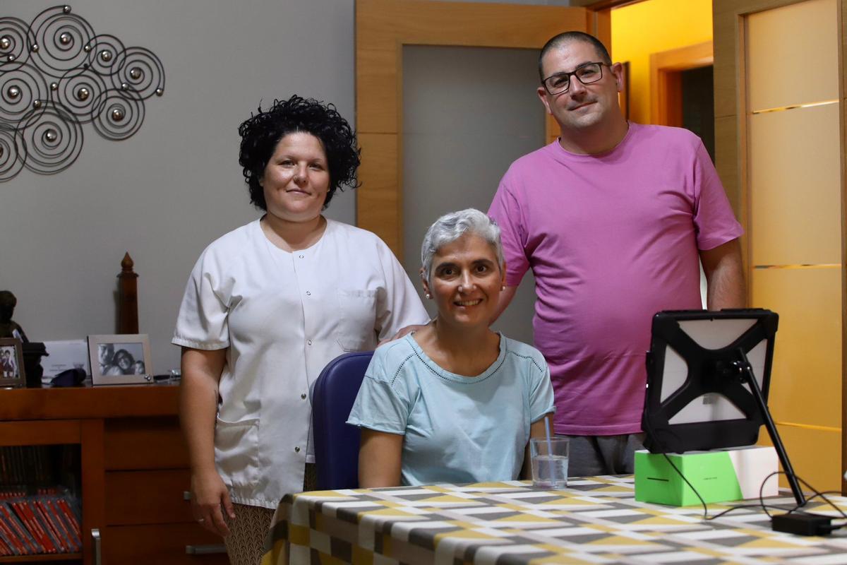 Susana Carmona, paciente de ELA, junto a su marido y la auxiliar que la ayuda en su casa.