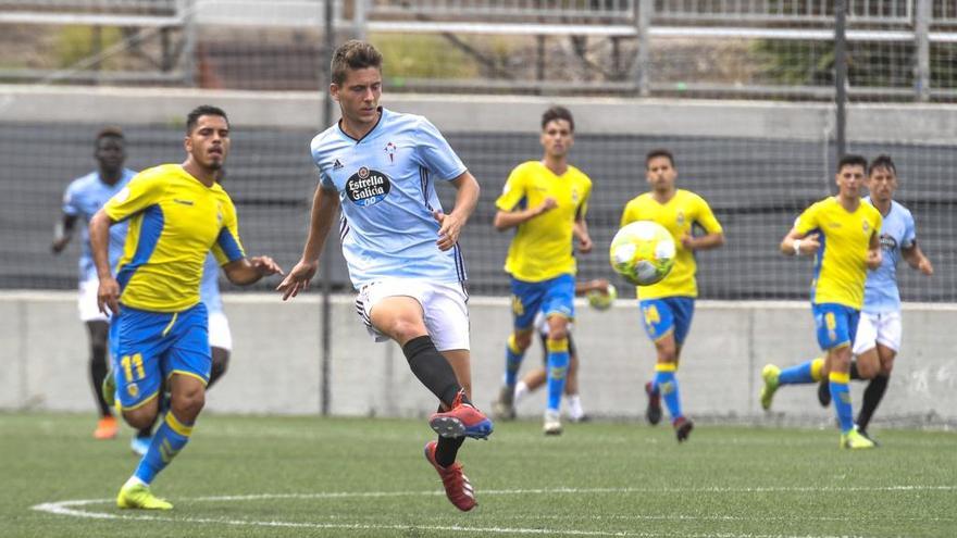 Un jugador del Celta B asiste a un compañero ante la mirada de un rival. // La Provincia