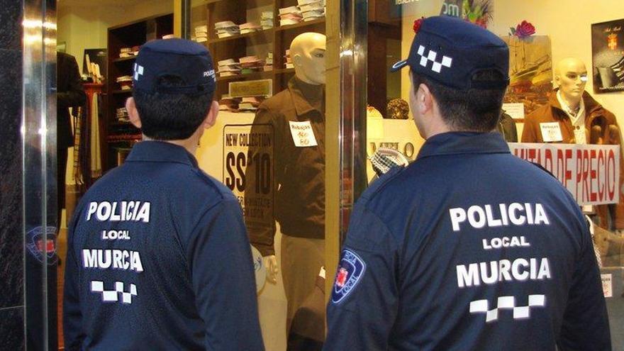 Dos agentes, en la puerta de un comercio.