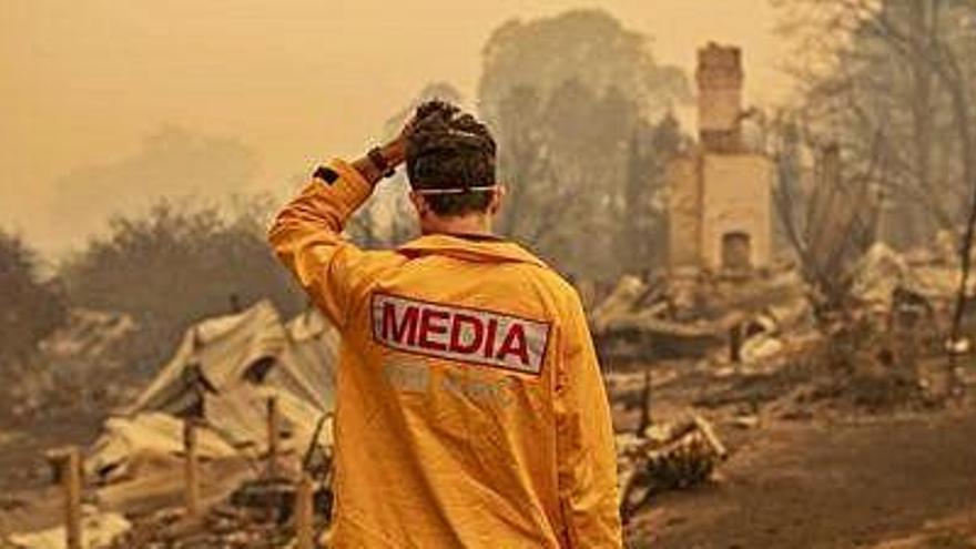 Un fotògraf observa la devastació causada pels incendis