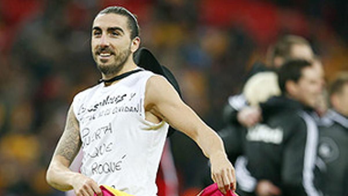 'Chico' Flores celebra el triunfo de su equipo con un capote y una camiseta con los nombres de Puerta, Jarque, Roqué y Preciado