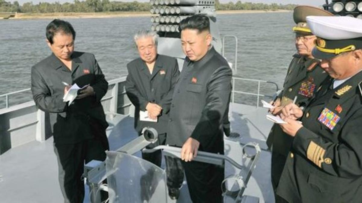 Kim Jong-un (centro) inspecciona un nuevo navío militar, en una foto facilitada el 12 de octubre por el régimen norcoreano, sin especificar la fecha del acto.