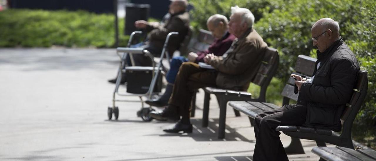 Unos pensionistas se relajan en un parque.