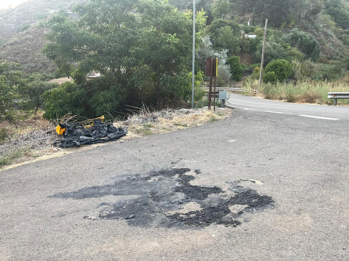 Un contenedor de basura quemado en una zona de vegetación durante la ola de calor.