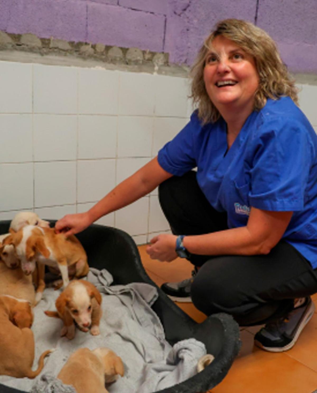 Olga Costa con varios cachorros en el Refugio de Animales.