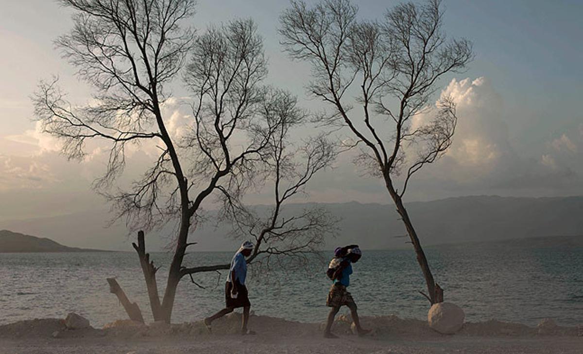 Dues dones, una d’elles amb un nen, caminen als voltants del llac Azuei, a Haití, a prop de la frontera amb la República Dominicana.