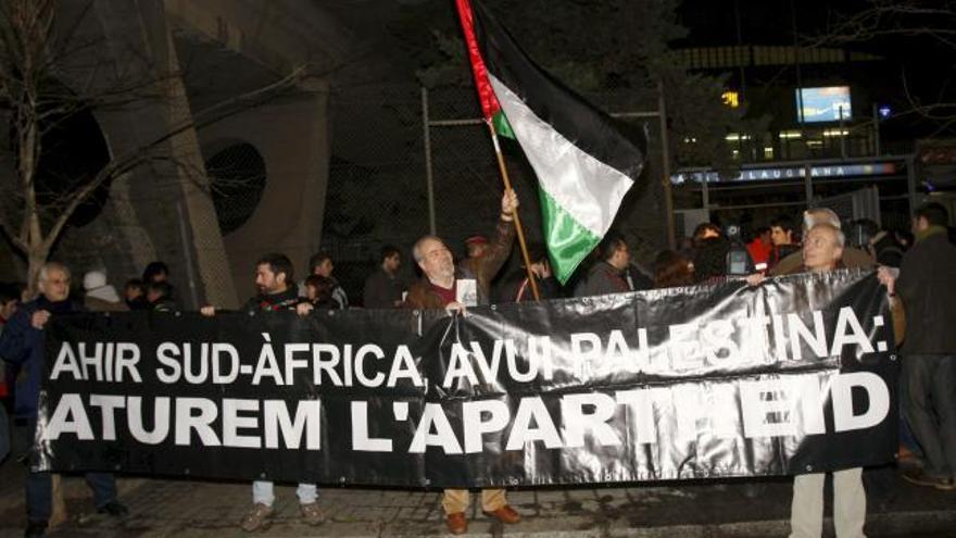 Varias personas sostienen una pancarta alusiva al conflicto de Palestina en las afueras del Palau Blaugrana de Barcelona, antes del inicio del partido de la Euroliga de baloncesto entre el Regal Barcelona y el Maccabi de Tel Aviv.