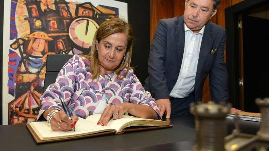 Silva firma en el Libro de Honor ante la mirada de Lores. // G. S.