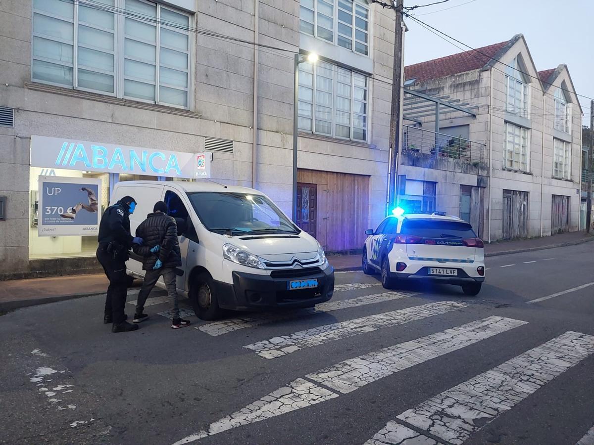 Un agente de la Policía Local de Cangas procede a la detención de uno de los implicados