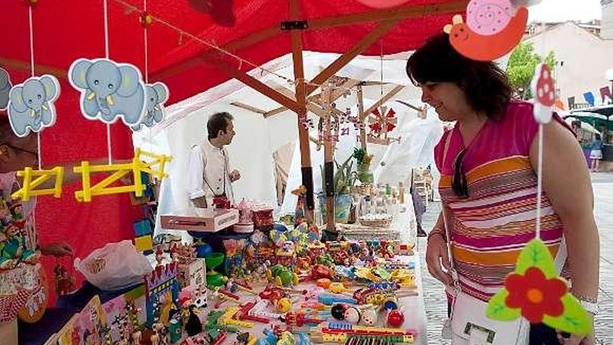 Una mujer, ayer, observando un puesto de juguetes en el mercado medieval.