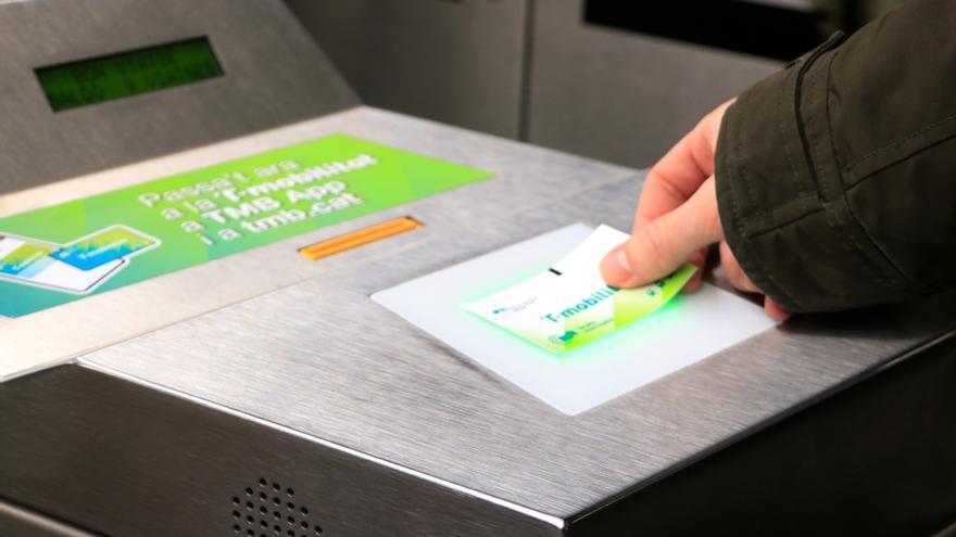 Un usuari valida la targeta de cartró recarregable de la T-Mobilitat, que s'acaba de comprar a l'estació de Sants de Barcelona.