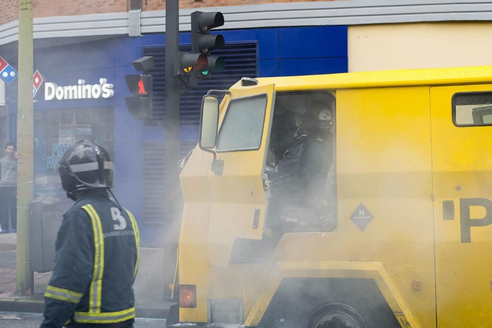 Bomberos trabajan en la extinción de un incendio en un camión blindado