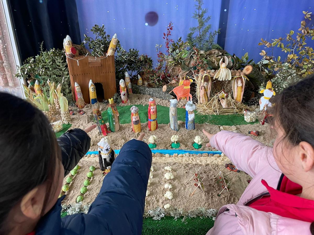 Varios niños, frente al belén del Corazón de María.