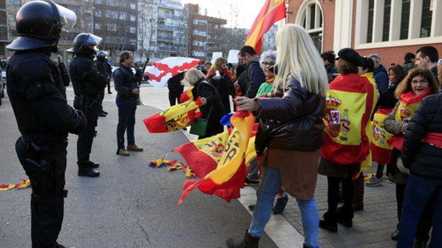 Manifestants amb banderes espanyoles, davant d&#039;un cordó dels Mossos d&#039;Esquadra, a l&#039;estació de tren de Sant Andreu Arenal el 16 de febrer