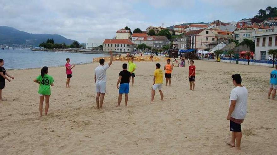 Un grupo de jóvenes juegan al balonmano en la playa de Arealonga, ayer. // FdV