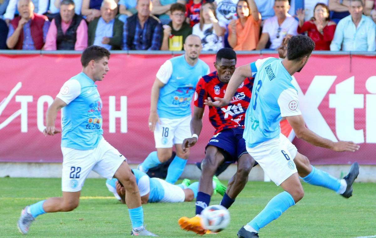 Boris Kouassi, delantero del Yeclano, intenta un disparo entre dos jugadores visitantes.  | PASCUAL AGUILERA