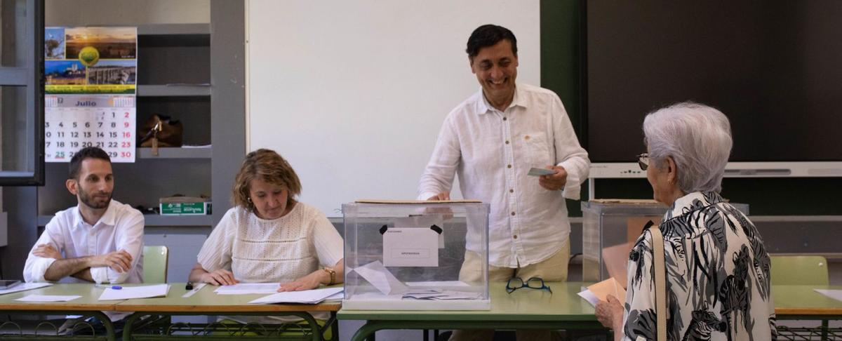 Una señora se acerca a la urna para introducir sus papeletas en la mesa electoral que le corresponde. | Ana Burrieza