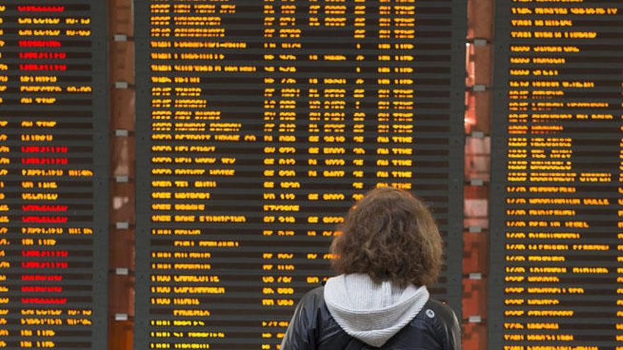 Una mujer observa el panel de vuelos en un aeropuerto de París.