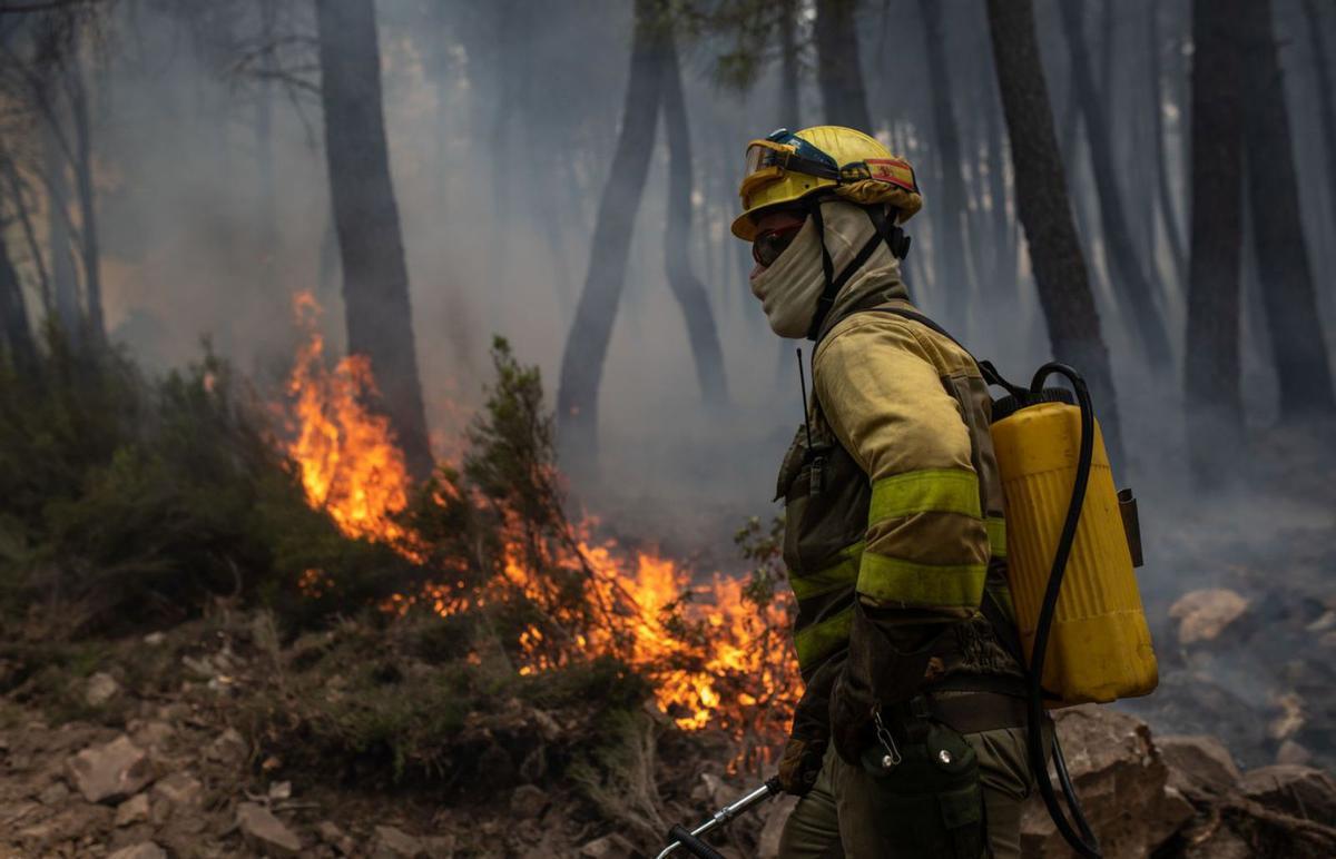 Un bombero forestal apaga un fuego. | Emilio Fraile