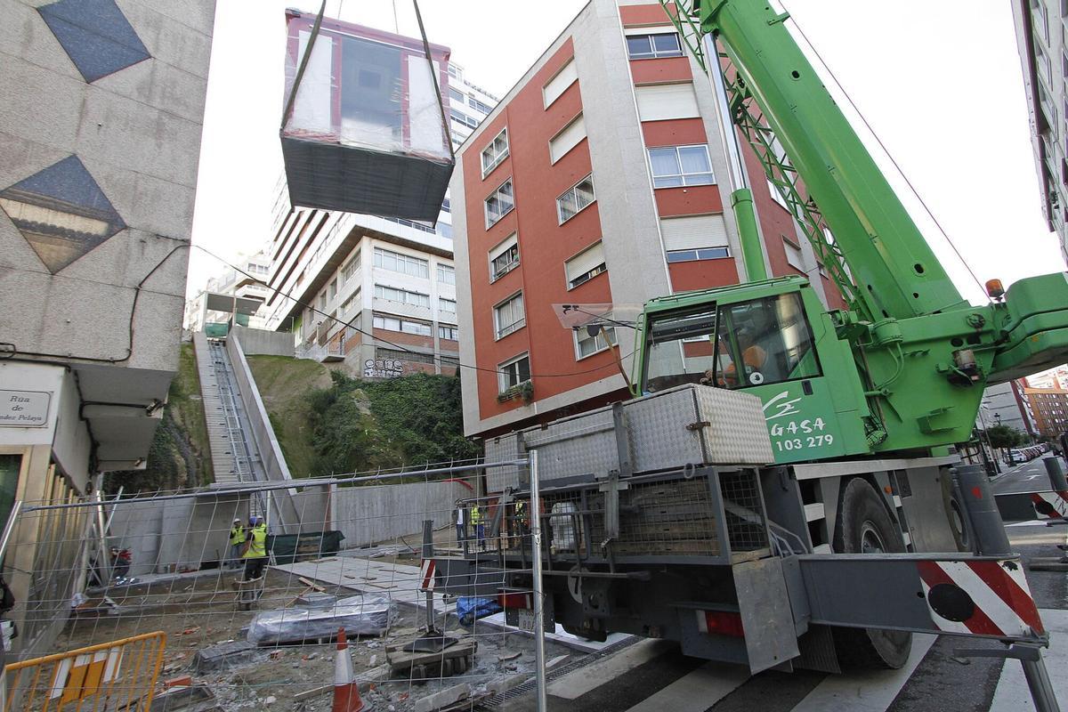Operarios montan la cabina del ascensor urbano de la calle Juan Ramón Jiménez, que unirá las calles Menéndez Pelayo y Camelias