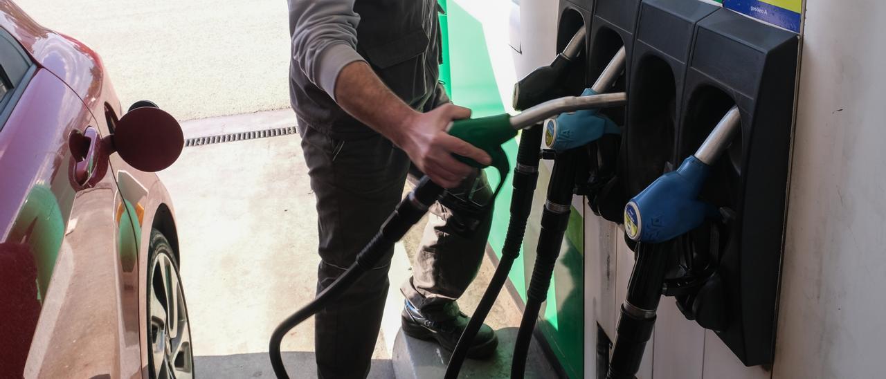 Un trabajador realiza un repostaje en una estación de servicio.