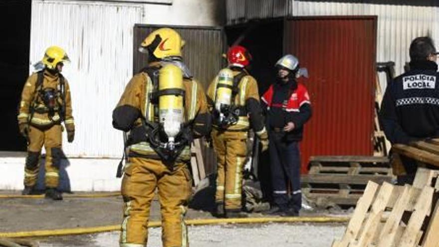 Los bomberos durante la extinción del incendio en la nave industrial dedicada a la fabricación de calzado en la pedanía de La Galia y en la vivienda.