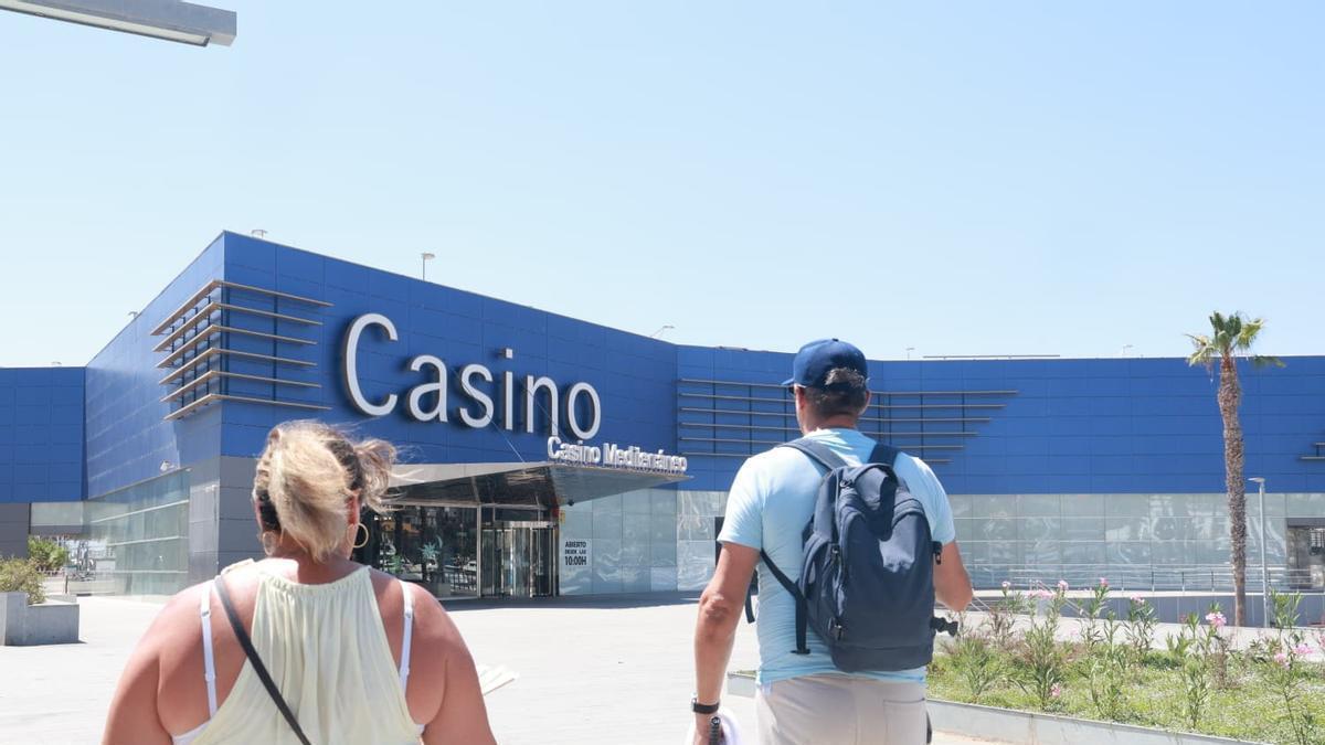Turistas pasan frente a la fachada del Casino Mediterráneo de Alicante.