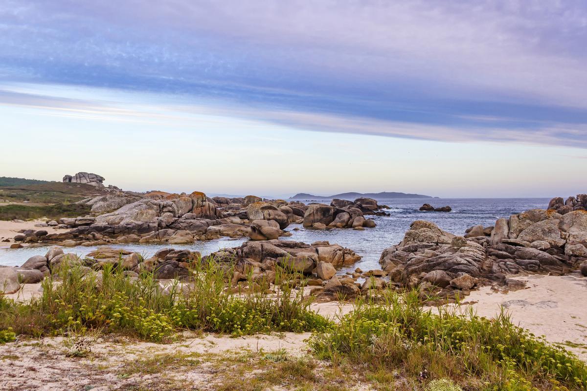 Rocas costeras con isla de Ons al fondo