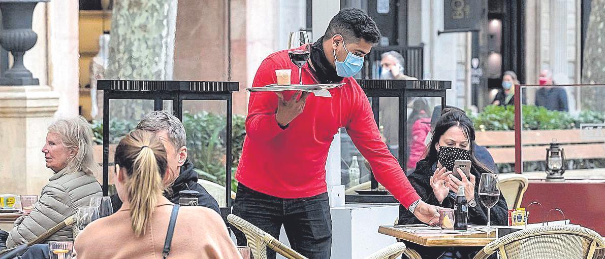 Un camarero sirve una consumición en una terraza.