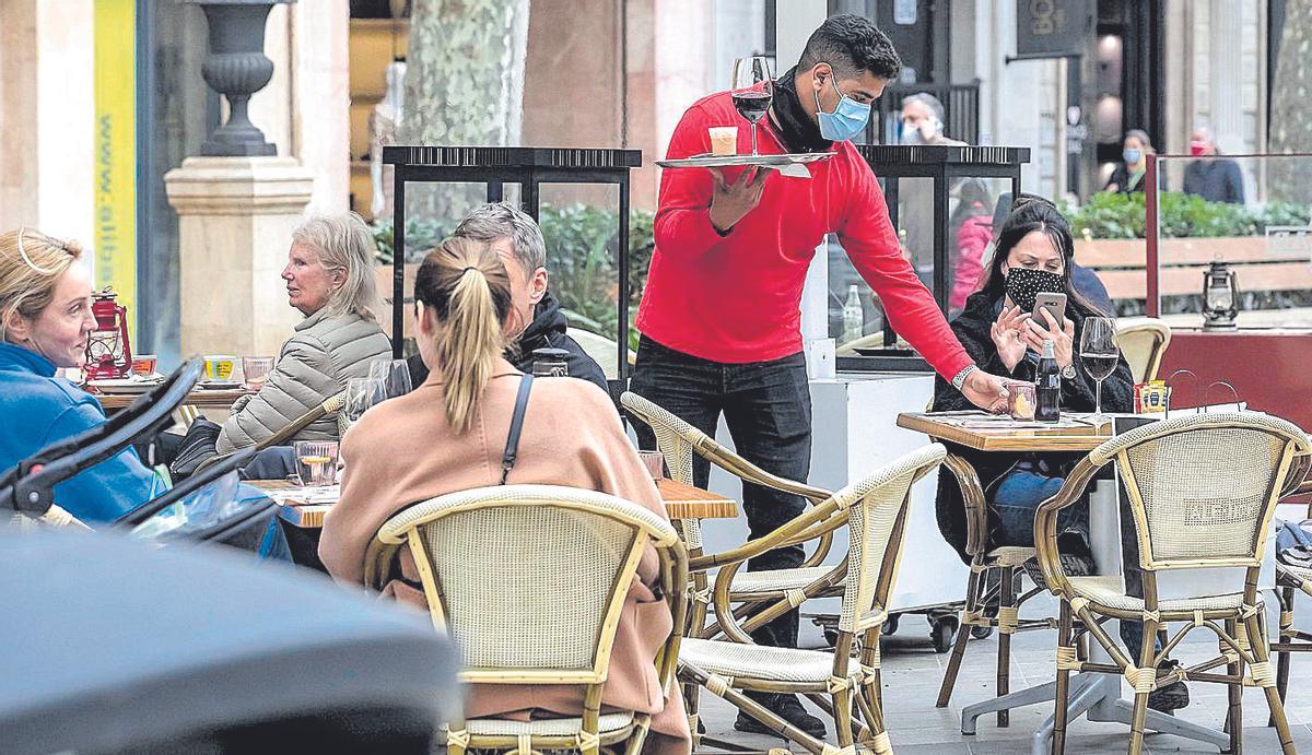 Un camarero sirve una consumición durante la pandemia.