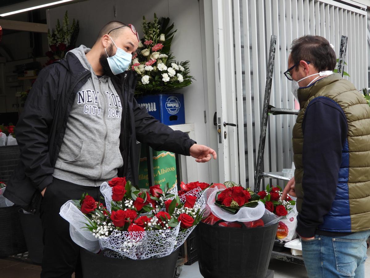Un florista con un cliente en la Plaza de Abastos. // FERNANDO CASANOVA